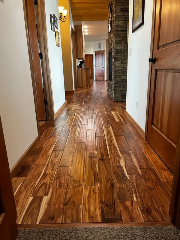 Beautiful warm hardwood floor with stone fireplace — a Wyoming home interior
