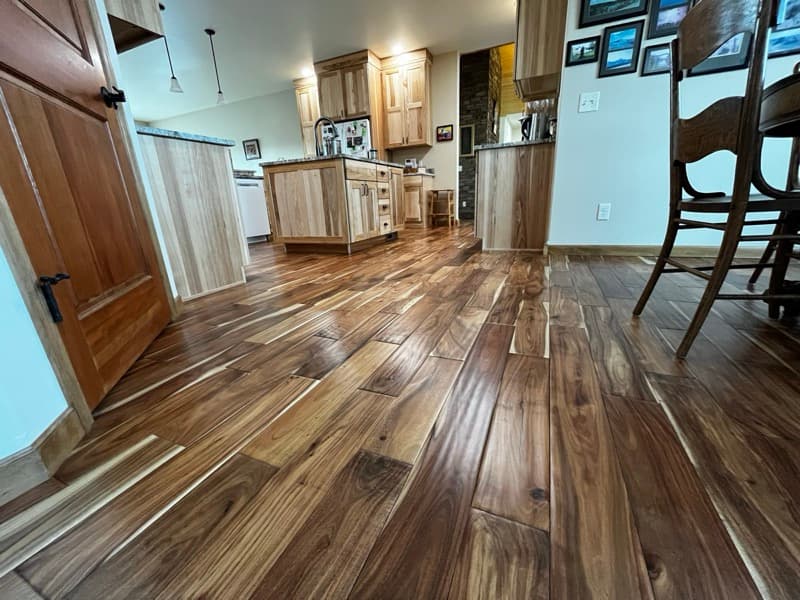 Polished hardwood floor with stone fireplace — restored by Legacy Wood Floors in Cody, Wyoming